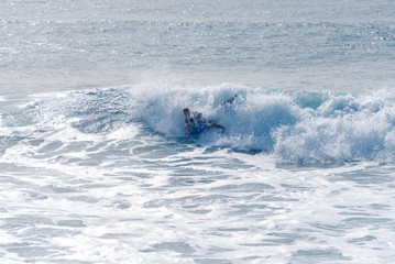 Obraz premium Bodyboarding and surfing in the waves of the Atlantic in front of the island La Gomera. A short light type of surfboard ridden in a prone position
