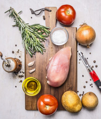 healthy food for athletes, tomatoes, onions, chicken breast, butter and salt potatoes on wooden rustic background top view close up