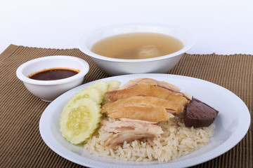 Hainanese chicken rice, steamed chicken, chicken blood and white rice on brown cloth background.