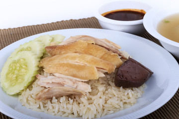 Hainanese chicken rice, steamed chicken, chicken blood and white rice on brown cloth background.