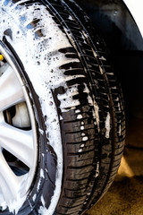 Fototapeta na wymiar close up washing a car tire with soap