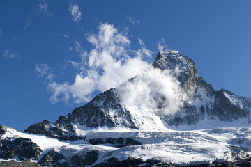 Fototapeta na wymiar Szczyt Matterhorn w śniegu i w chmurach