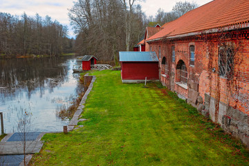 Old red brick building over pond © Igor Groshev