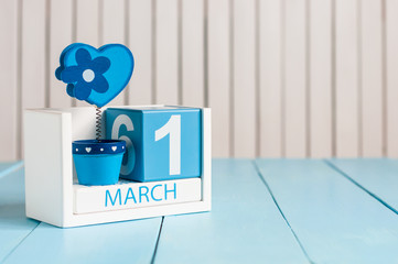 March 1st. Image of march 1 wooden color calendar with flower and heart on white background.  First spring day, empty space for text