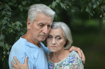 Sad senior couple in  park