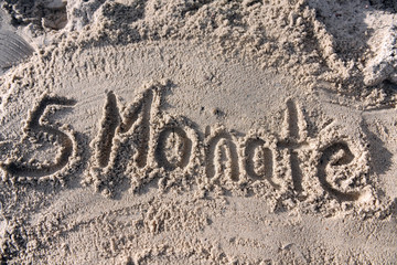 Fototapeta premium 5 Monate - geschrieben im Sand