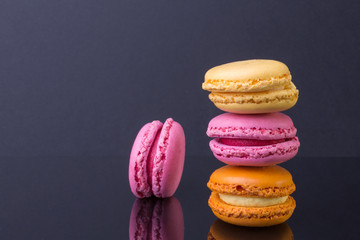 French fine traditional baking of eggs, almond flour, sugar and berries. color small cookies on a black background. side view from the top, a bright colorful image with space for text