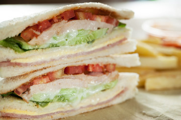 homemade club sandwich with french fries