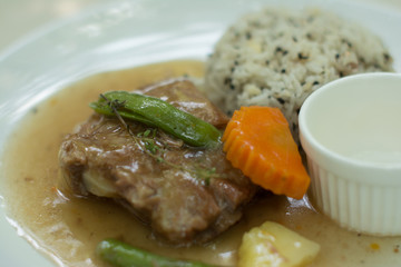 Pork ribs with gravy served with herbal rice and salad