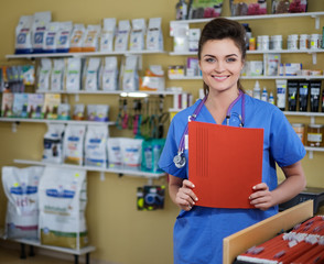 Portrait of beautiful nurse with folder at veterinary clinic.