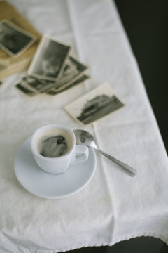 Cup of coffee and photographs on the table