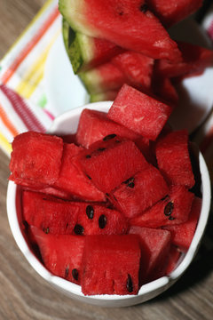 slices of watermelon in a bowl on a blurred background