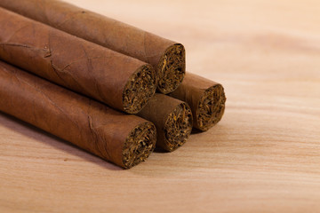 Different cigars on wooden desk