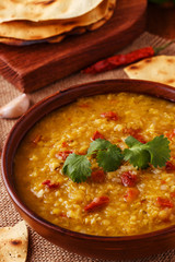 .Thick indian red lentil soup with cilantro served with indian f