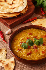 .Thick indian red lentil soup with cilantro served with indian f