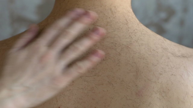 Brushing away hair from the man's neck
