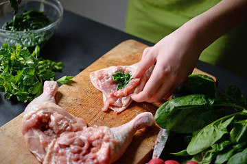 Young woman preparing chicken with vegetables