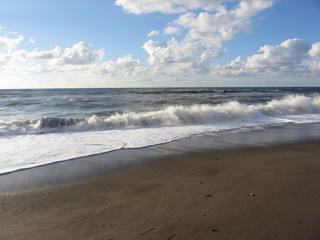 Wave of the sea on the sand beach. Castiglione della Pescaia, Province of Grosseto, Italy