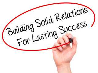 Man Hand writing Building Solid Relations For Lasting Success wi