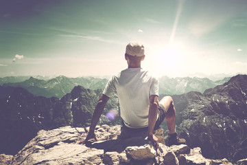 Rear view of hiker at the top of a rock or summit