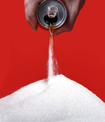 cola refreshing drink can pouring the liquid as its transforming into pure white sugar