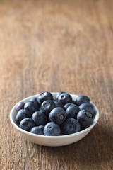 Blueberries in bowl on wooden. Blueberry contain antioxidant org