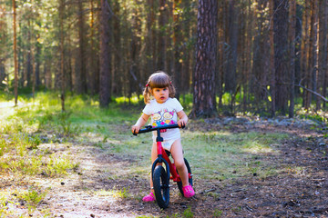 little girl alone in the woods on  bike.