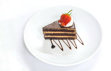 layer dark chocolate cake garnishing with sliced red strawberry on topping cream