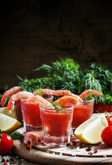 Shrimp cocktail in small glasses, cherry tomatoes, dill, parsley