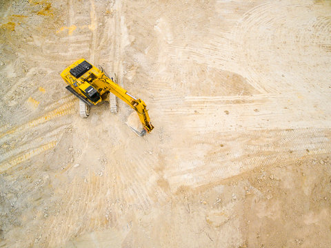 Aerial view of working excavator in the opencast mine. Industrial background on digging theme. Use drones to inspect of your business. 