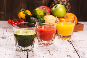 Fototapeta na wymiar Fruit and vegetable smoothies and juice with ingredients over wooden background. Toned image. Selective focus
