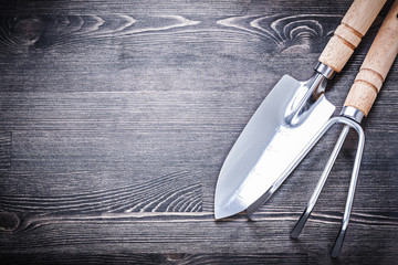 Stainless spade rake on wooden board gardening concept