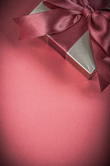 Wrapped present box on red background holidays concept