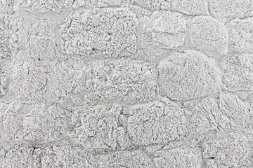 wall of granite stones covered with hoarfrost 