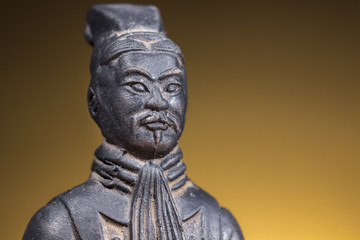 Fototapeta na wymiar Close-up of terracotta figurine of ancient chinese warrior on rising sun background