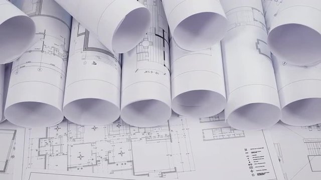 Camera slides over architectural blueprints scattered randomly on desk
