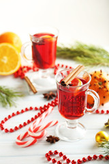 Mulled wine in glass on white wooden table