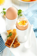 Boiled egg with toasts on a blue wooden table