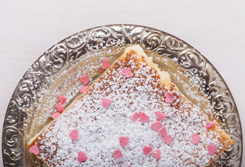 Obraz na płótnie Canvas Homemade cake on a metal plate on colored wooden background