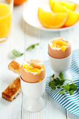 Boiled egg with toasts on a blue wooden table