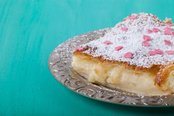 Homemade cake on a metal plate on colored wooden background. Sel