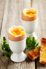 Boiled egg with toasts on a grey wooden table