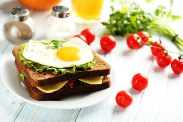 Fried eggs with toasts on plate on blue wooden table