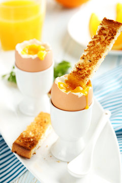 Boiled egg with toasts on a blue wooden table