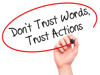 Man Hand writing Don't Trust Words, Trust Actions with black mar