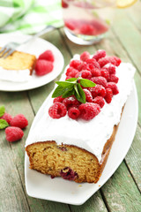 Raspberry cake on plate on green wooden background