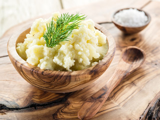 Mashed potatoes in the wooden bowl on the service tray.