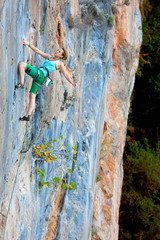 Extreme Sport Athlete hanging on vertical natural Wall