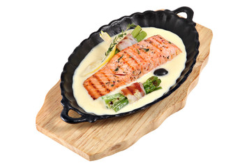 Fried salmon with cream sauce and green asparagus in bacon.