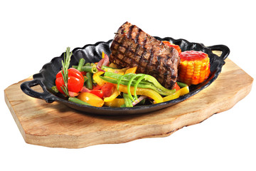 Mexican steak with vegetables in cast iron oval serving platter.